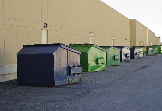 a construction worker moves construction materials near a dumpster in Clawson MI